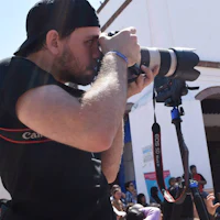 a man taking a picture with a camera in front of a crowd