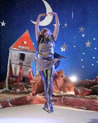 a woman on an ice rink with a moon and stars in the background