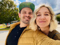 a man and woman taking a selfie in front of a tree