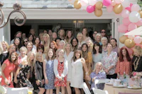 a group of women posing in front of balloons