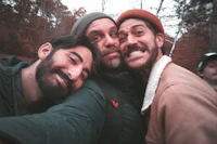three men posing for a selfie in the woods