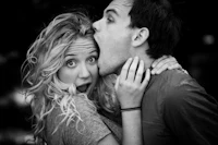 a black and white photo of a man and woman kissing