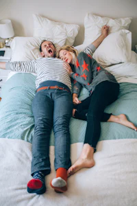 a man and woman laying on a bed