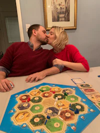 a man and woman kissing in front of a board game